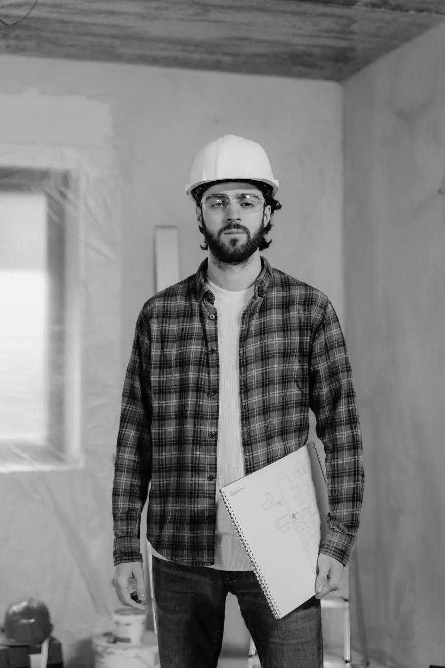 Trabajador con casco blanco revisando un presupuesto de obra