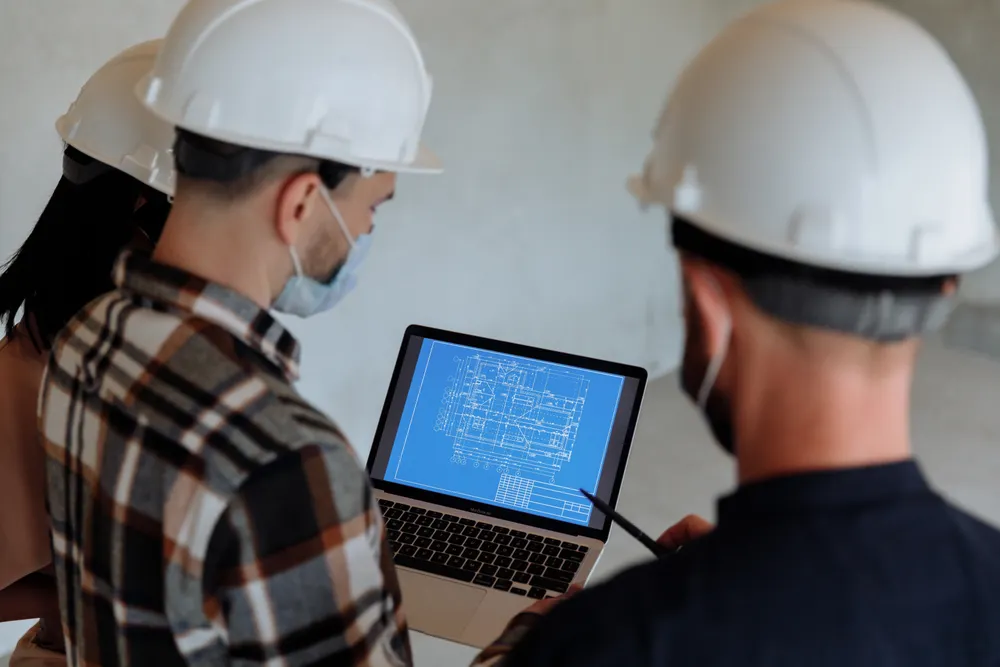 Equipo técnico revisando planos digitales en una tableta en obra