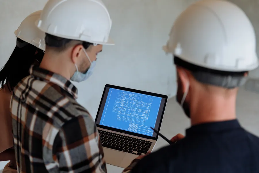 Equipo técnico revisando planos digitales en una tableta en obra